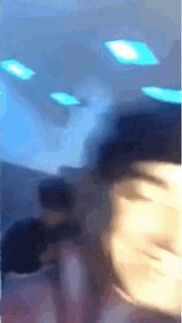a blurry picture of a person 's face with a blue light in the background