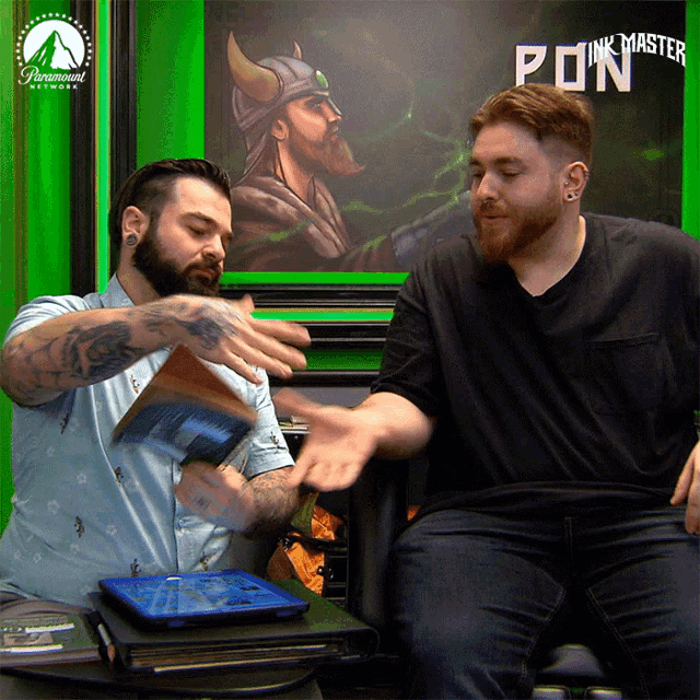 two men are sitting in front of a sign that says paramount network