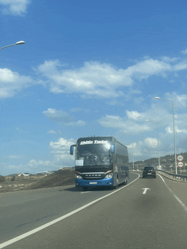 a blue secon bus is driving down the road