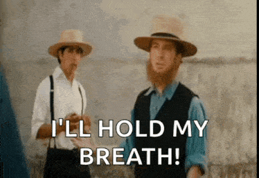two men in hats are standing next to each other in a field and one of them is saying `` i 'll hold my breath ''