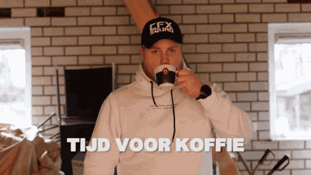 a man wearing a cfx squad hat drinks from a mug