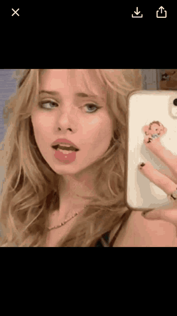 a woman is taking a selfie with her phone in front of a mirror