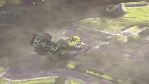 a monster truck is going down a dirt track in front of a thunder alley sign