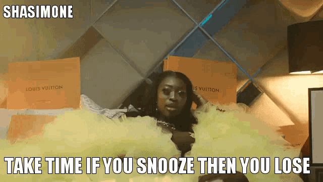 a woman in a yellow dress is laying on a bed with louis vuitton boxes behind her
