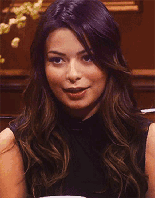 a woman with purple hair is smiling and wearing a black shirt