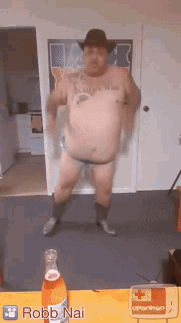 a man in a cowboy hat is dancing next to a bottle of robb nai soda