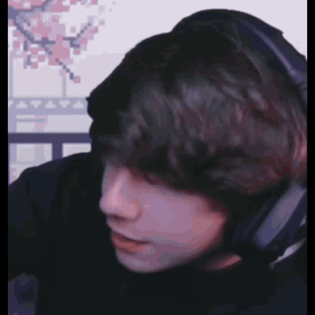 a close up of a person wearing headphones with a pixelated background