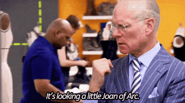 a man in a suit is talking about joan of arc