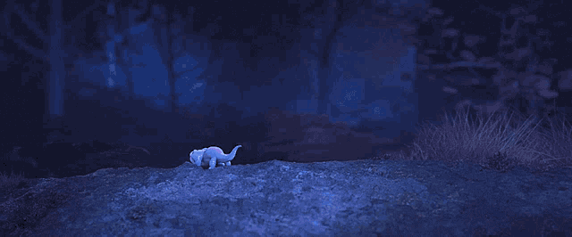 a small lizard is flying through the air in a dark forest