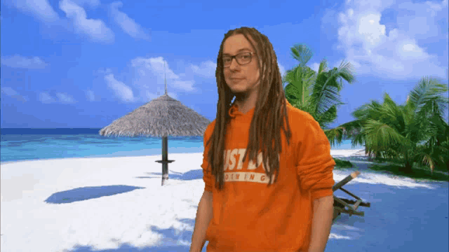 a man with dreadlocks is wearing an orange shirt that says just doing it