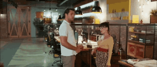 a man and a woman are holding hands in an office .