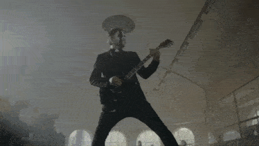 a man wearing a mask is playing a guitar on the stairs