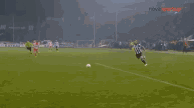 a blurry picture of soccer players on a field with a scoreboard in the background that says sports.gr