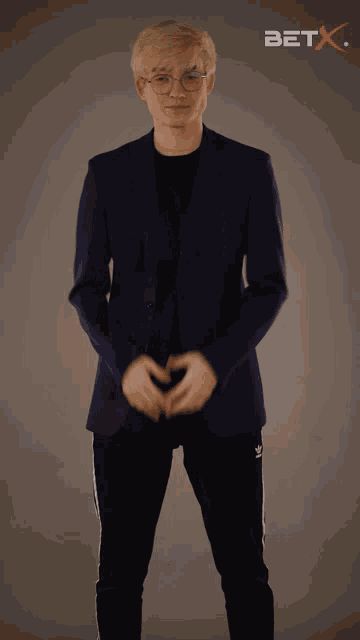a man in a suit is standing in front of a bet x logo