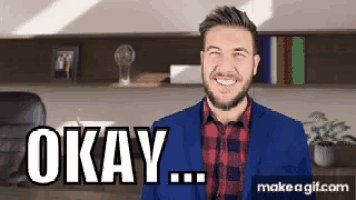 a man in a suit and plaid shirt is smiling and says " okay "