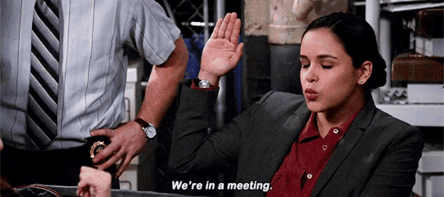 a woman says we 're in a meeting while sitting at a table