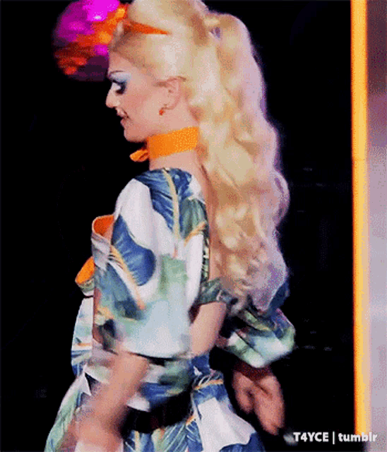 a woman with blonde hair is wearing a colorful dress