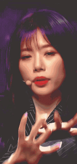 a close up of a woman with purple hair and red lipstick