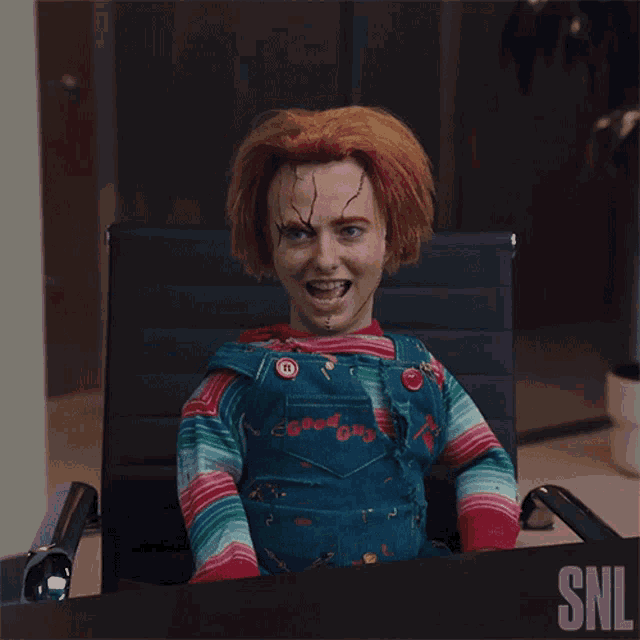 a chucky doll is sitting in a chair with a snl logo in the background