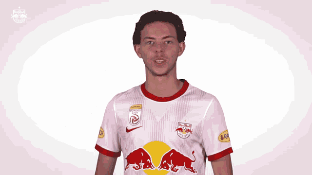 a man wearing a red bull jersey is making a fist