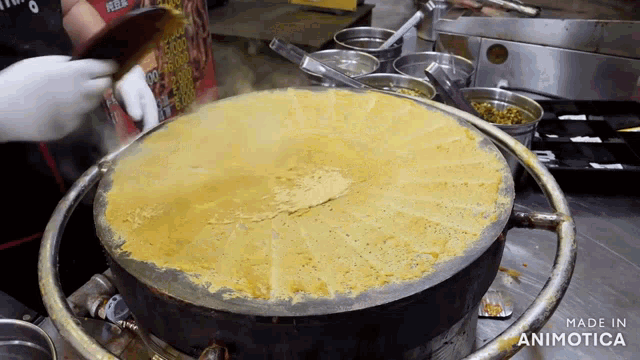 a large pan of food is being cooked on a stove and the words made in animotica can be seen on the bottom