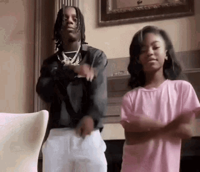 a man and a woman are dancing together in a living room .