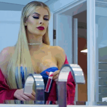a woman is looking at herself in a mirror while holding a toothbrush