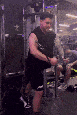 a man in a gym using a machine that says jore on his shorts