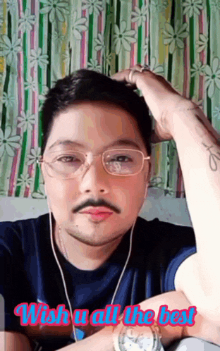 a man with glasses and a mustache is wearing headphones and a watch and says wish u all the best