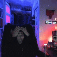 a man is sitting in a chair with his hands on his head in a room with a sign that says 00000 on it