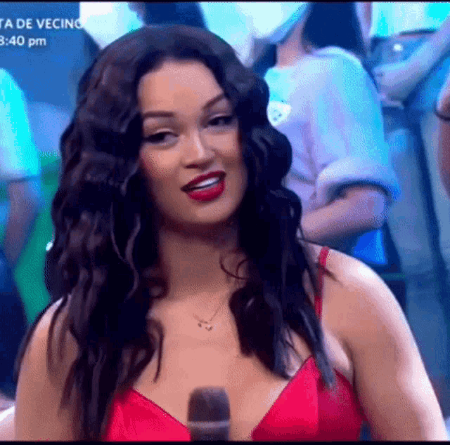 a woman in a red bra is sitting in front of a microphone .