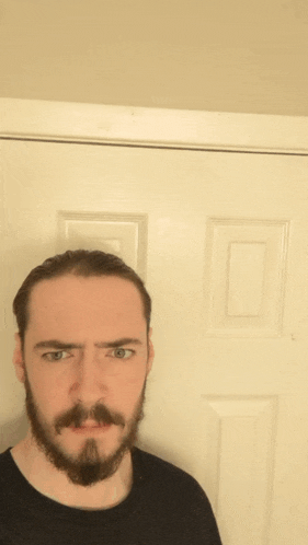 a man with a beard and mustache is pointing up