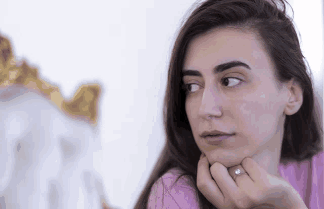 a woman with a ring on her finger looks at herself in the mirror
