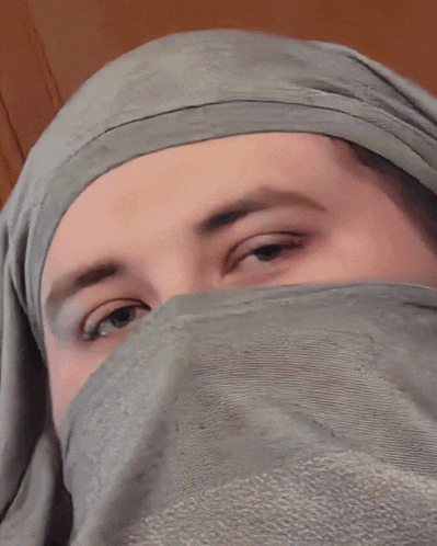 a close up of a man 's face with a hoodie on