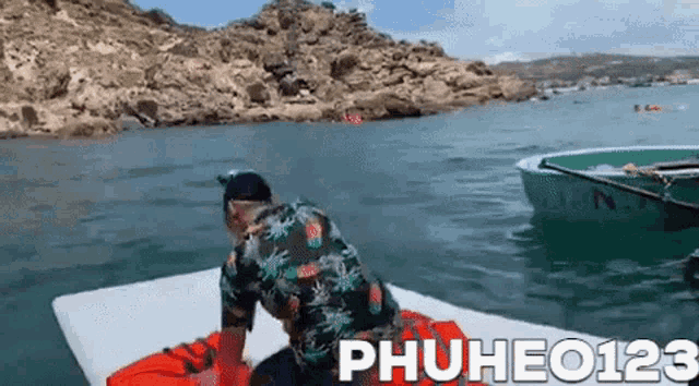 a man is sitting on a raft in the middle of the ocean .