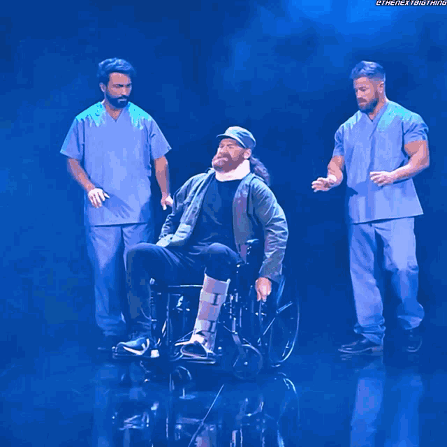 a man in a wheelchair with a bandage on his leg is surrounded by two men in scrubs