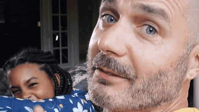 a man with a beard holds a child in his arms