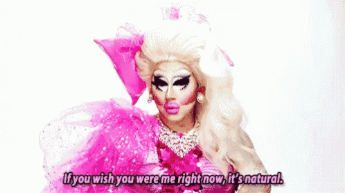 a drag queen is wearing a pink dress and saying `` if you wish you were me right now , it 's natural . ``