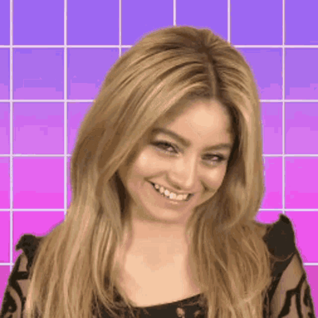 a woman with blonde hair is laughing and covering her mouth with her hand .
