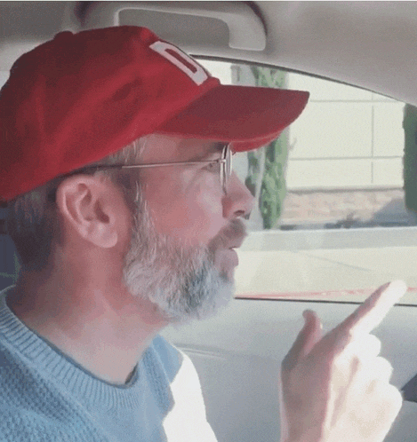 a man with a beard wearing a red hat with a letter d on it