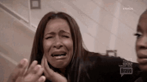 a woman is crying in front of a screen that says #rhoa