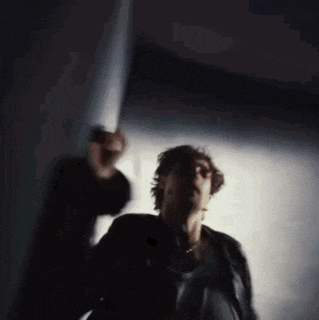 a blurry photo of a man in a black jacket standing in a dark room