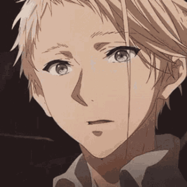 a close up of a boy 's face with blonde hair and blue eyes