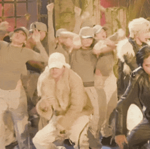 a group of people are dancing in a dark room