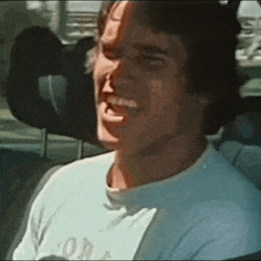 a man is sitting in the back seat of a car laughing .