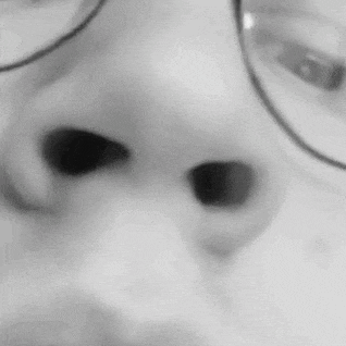 a black and white photo of a person wearing glasses .