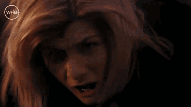 a close up of a woman 's face with a shocked expression .