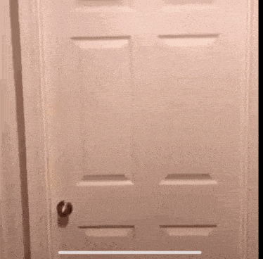 a man with a beard is peeking through a door .