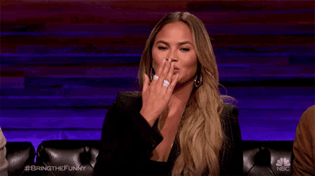 a woman with a ring on her finger is covering her mouth