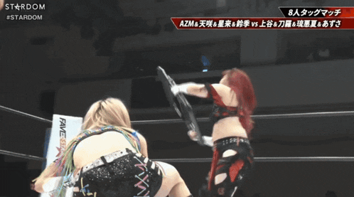 a wrestling match between azm and a man with a sign that says stardom on it